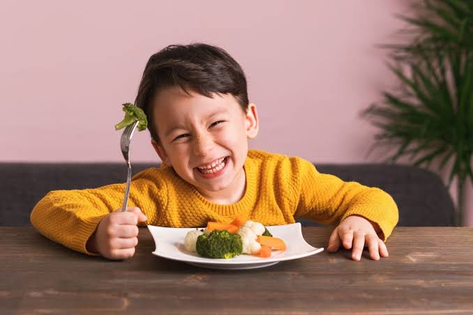 child eating vegetables