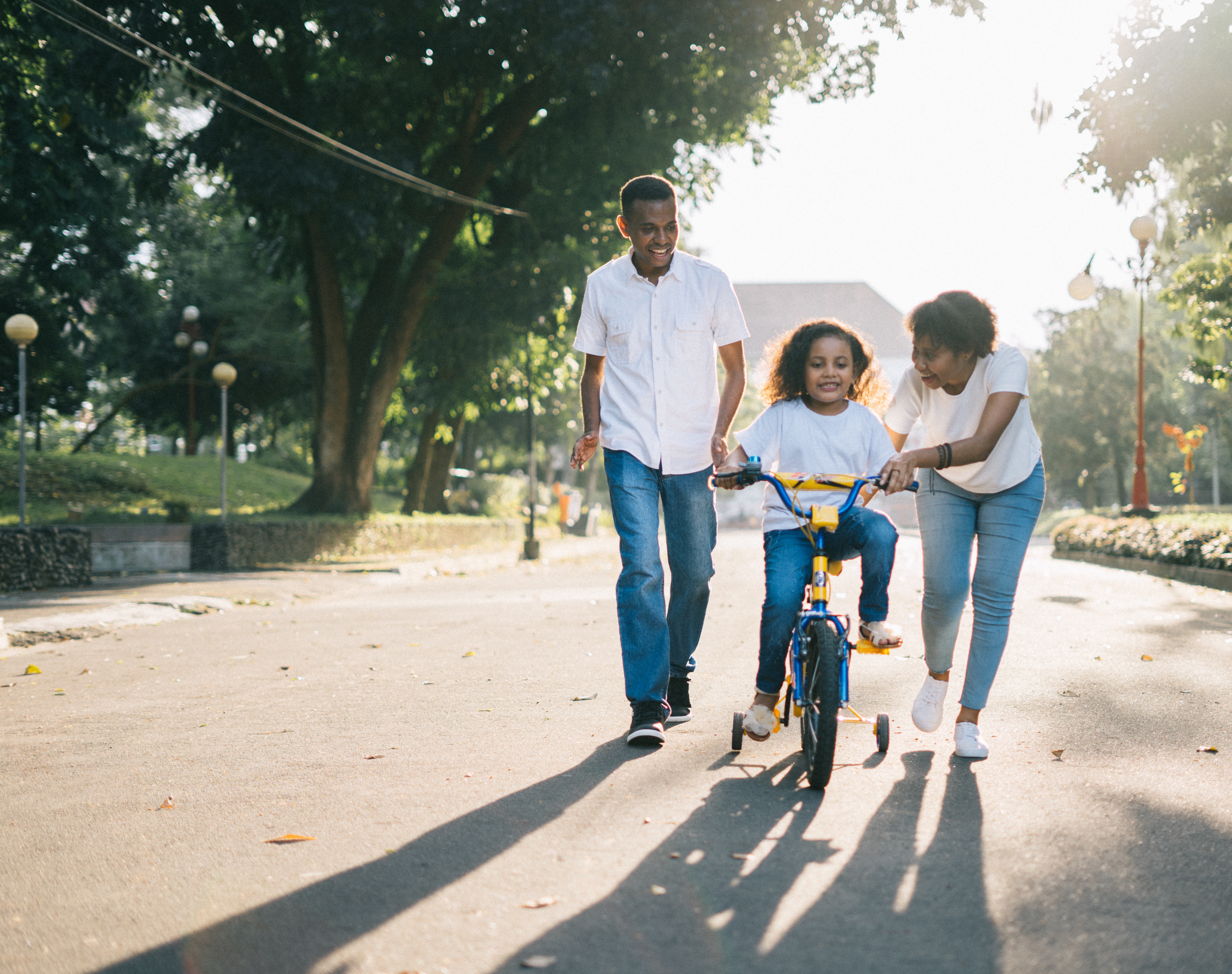 parents showing compassion towards a daughter who learn how to ride a bike